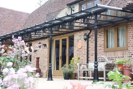 A brick house with a glass canopy over the porch.