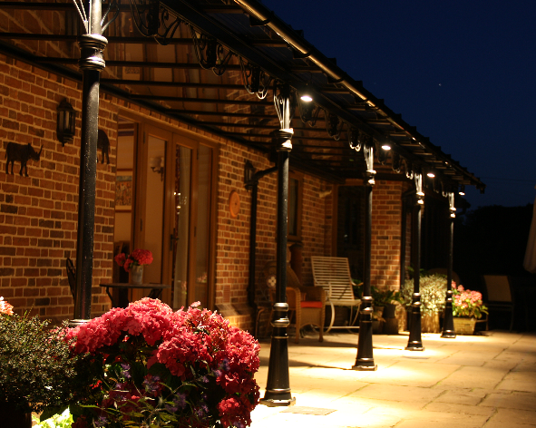 A brick building with a porch and flowers in front of it