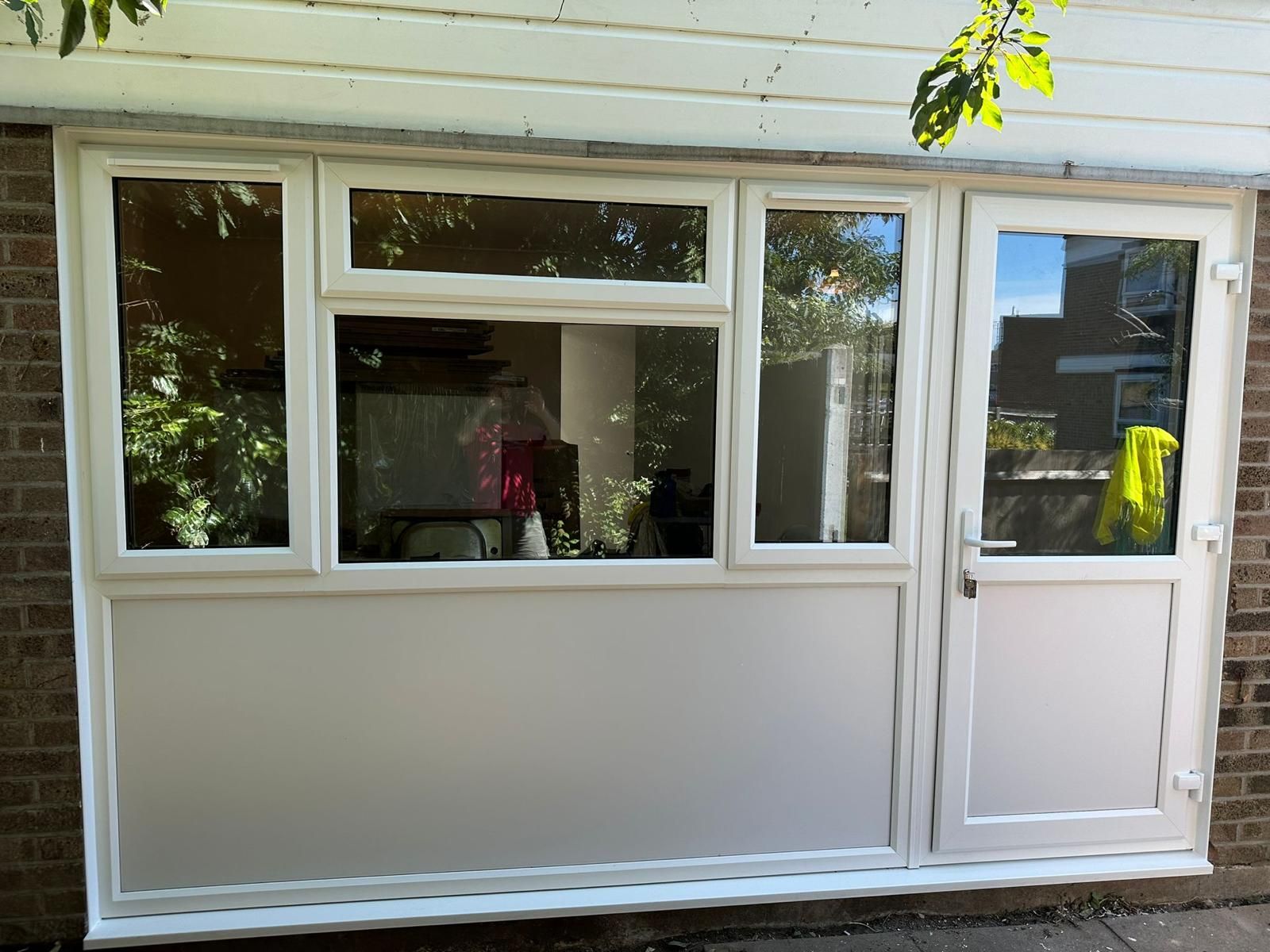 A white door and window on a brick building