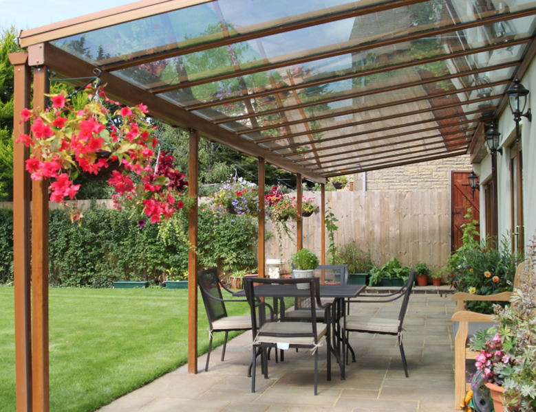 A patio with a table and chairs under a clear roof.