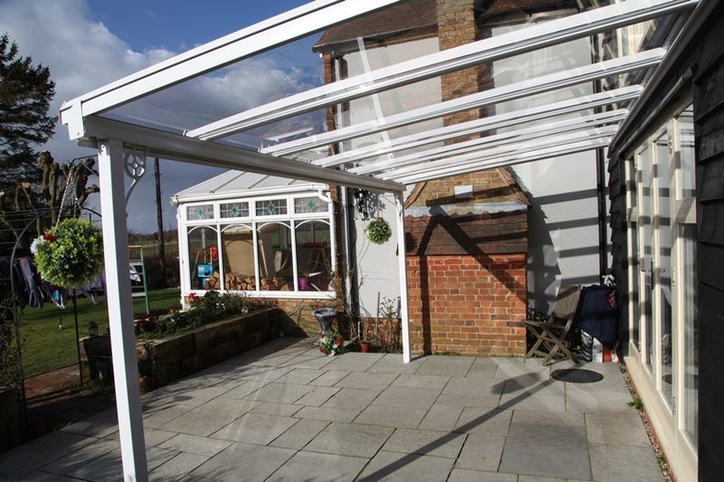 A patio with a canopy over it in front of a house.