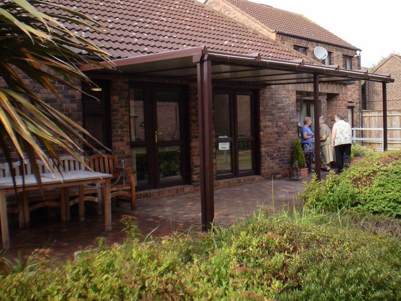 A group of people standing outside of a brick house