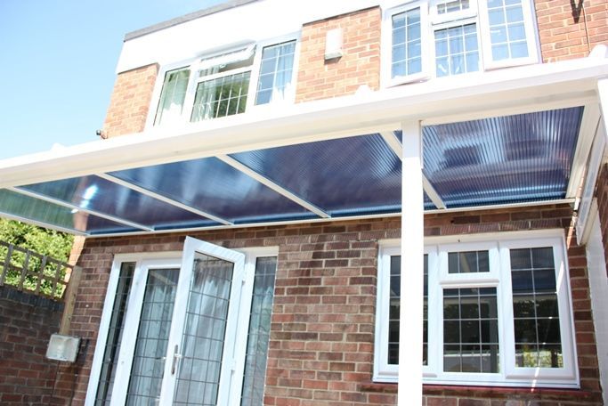 A brick house with a canopy over the door and windows.