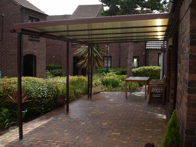 A patio with a table and chairs under a canopy