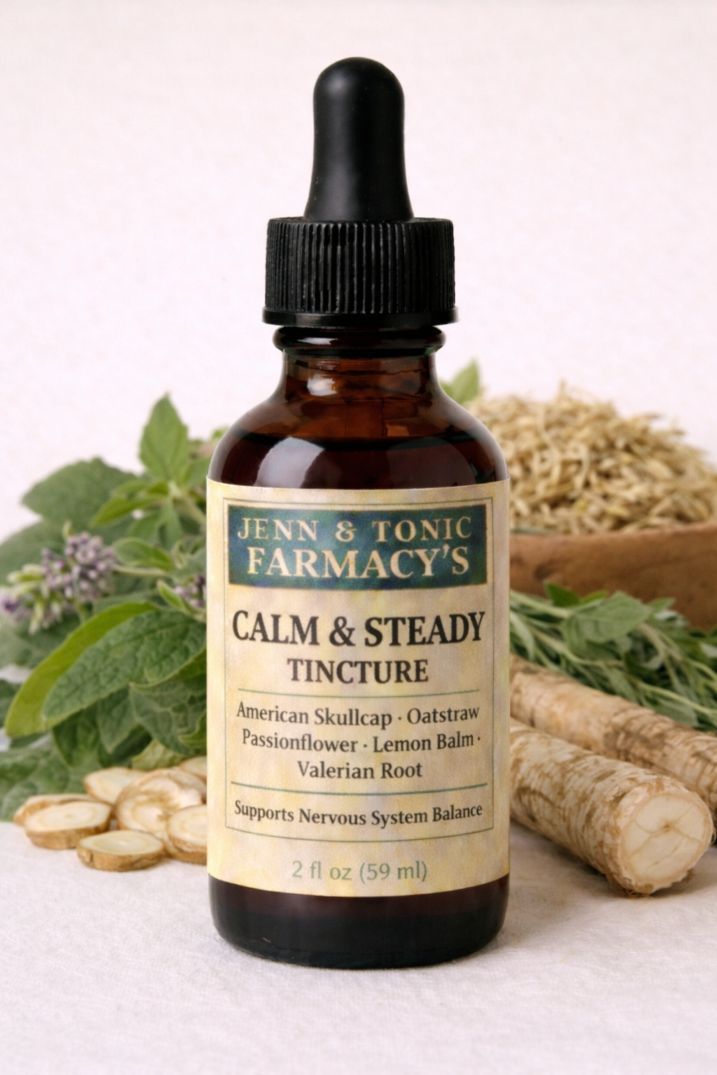 A bottle of Jenn & Tonic Farmacy’s Calm & Steady Tincture, surrounded by fresh herbs and roots on a white background.