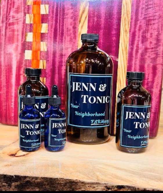 Several bottles of jenn & tonic are sitting on a wooden table