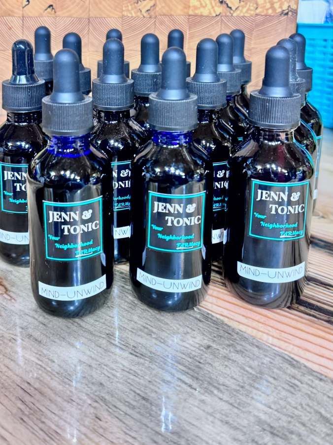 A row of jenn tonic bottles are sitting on a wooden table.