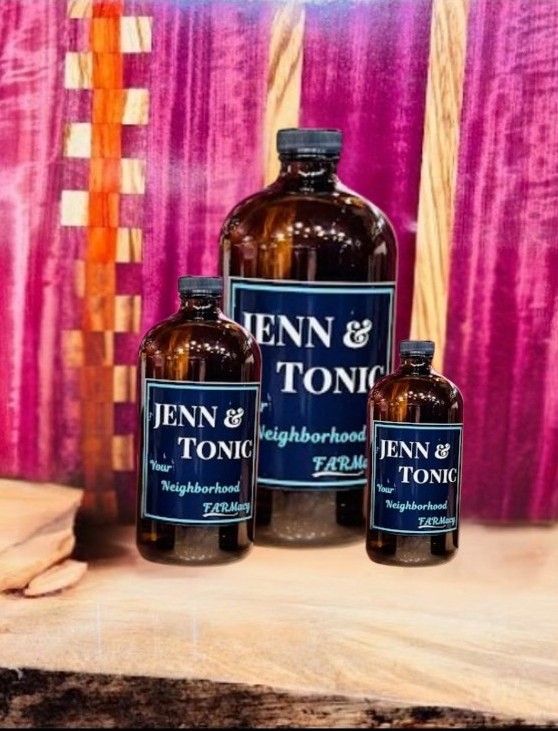 Three bottles of jenn & tonic sit on a table