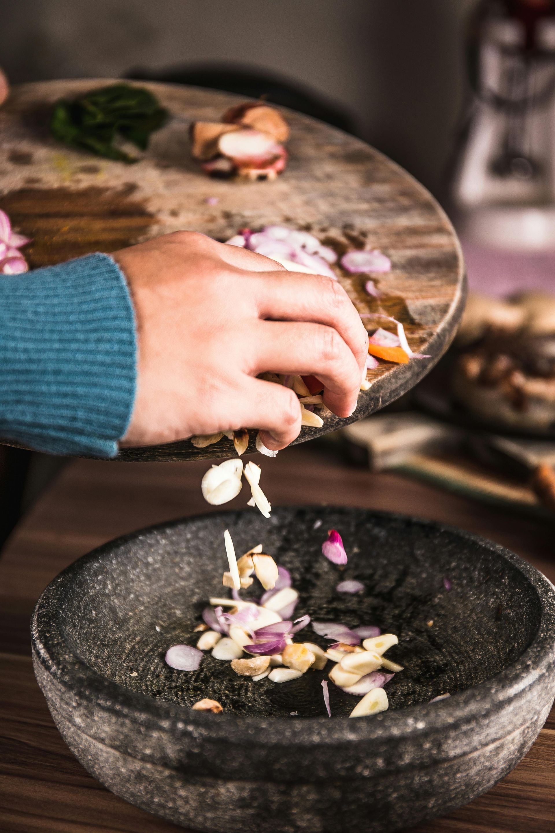 A person is pouring vegetables into a bowl.
