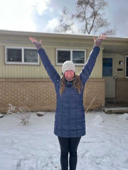 A girl holding her arms up in the air with excitement