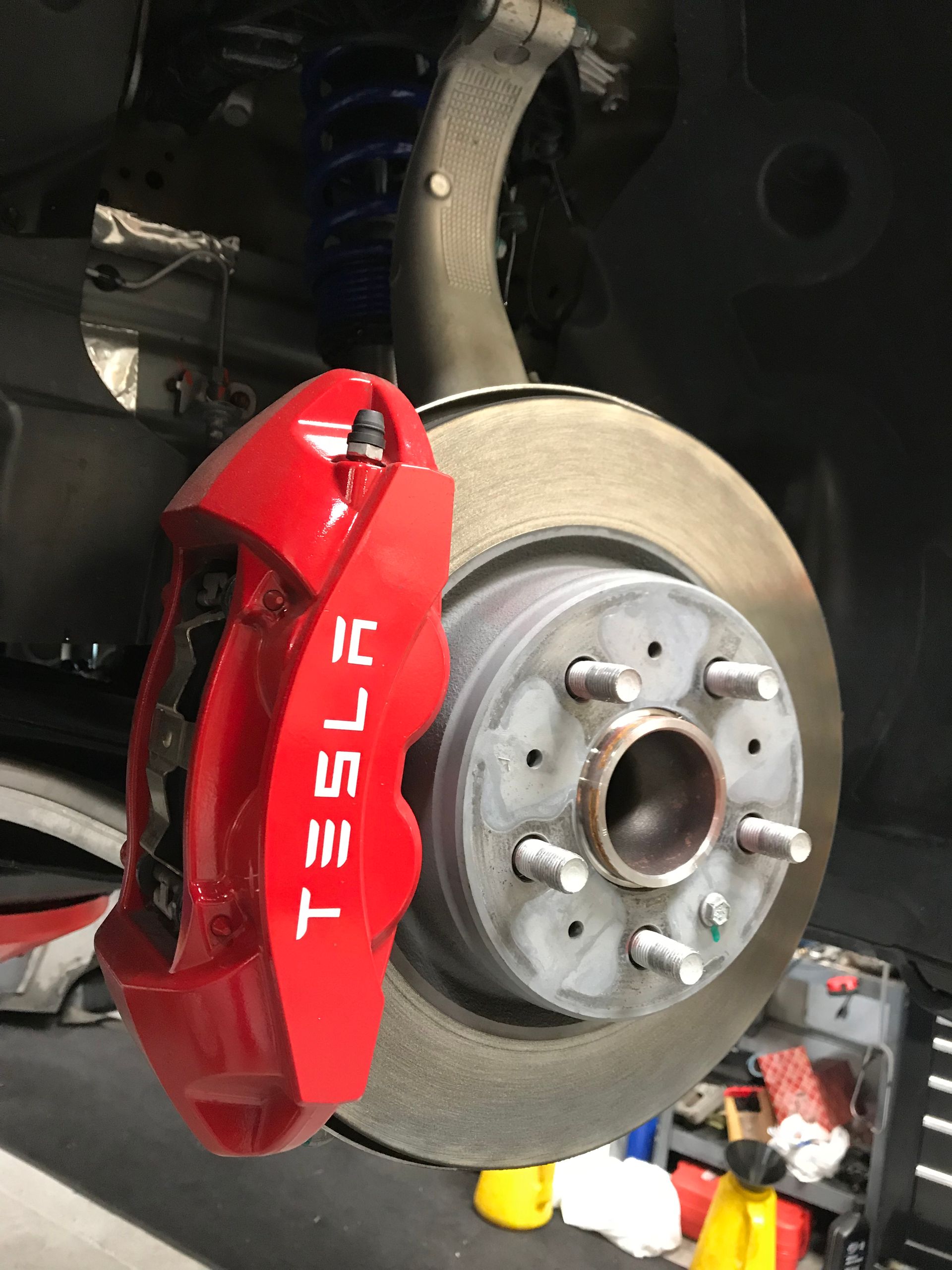 A tesla car has a red brake caliper on it | Griffin Motorwerke