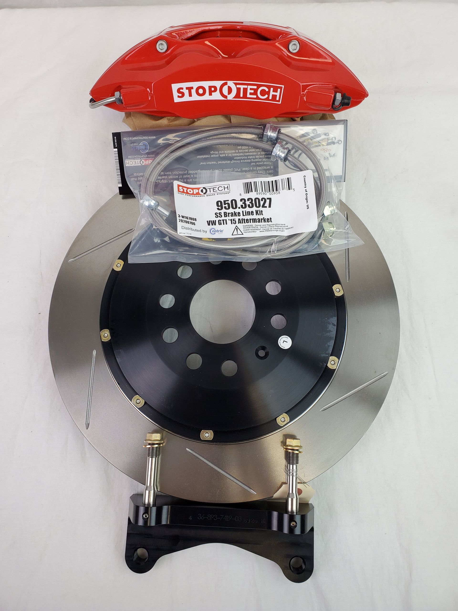 A red stop tech brake caliper sits on top of a brake disc | Griffin Motorwerke