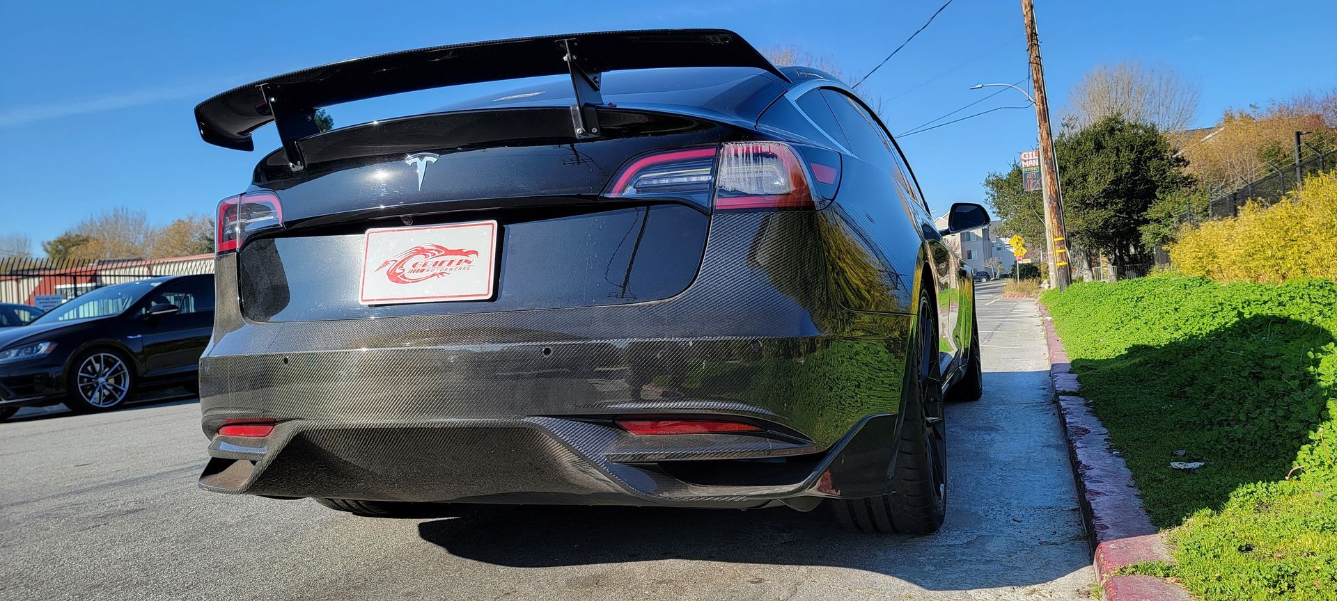 A black tesla model x is parked on the side of the road | Griffin Motorwerke