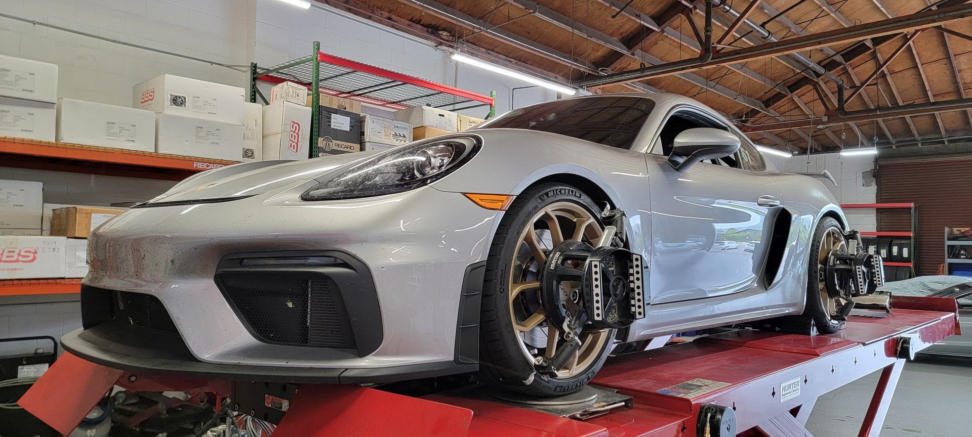A silver sports car is sitting on top of a red lift in a garage | Griffin Motorwerke