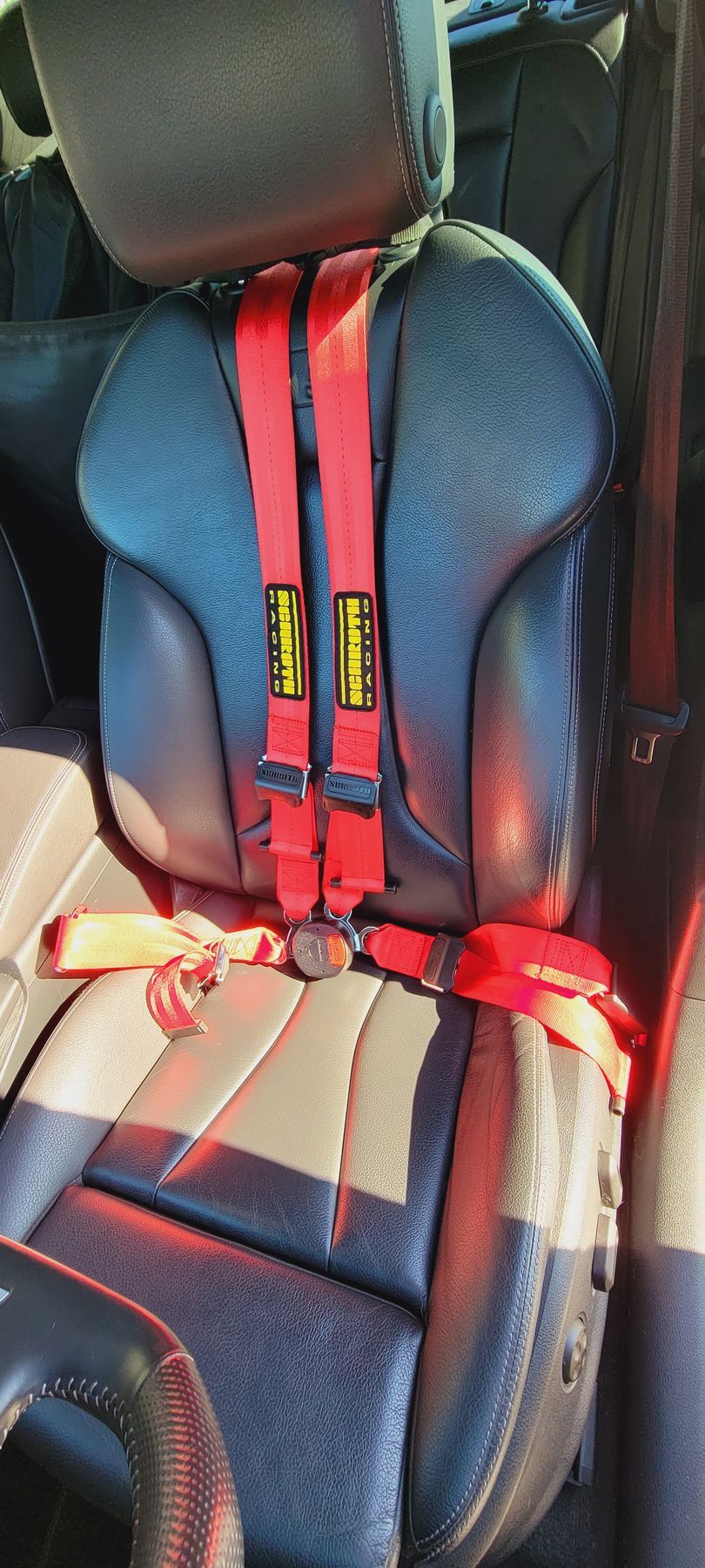 A car seat with a red seat belt attached to it | Griffin Motorwerke