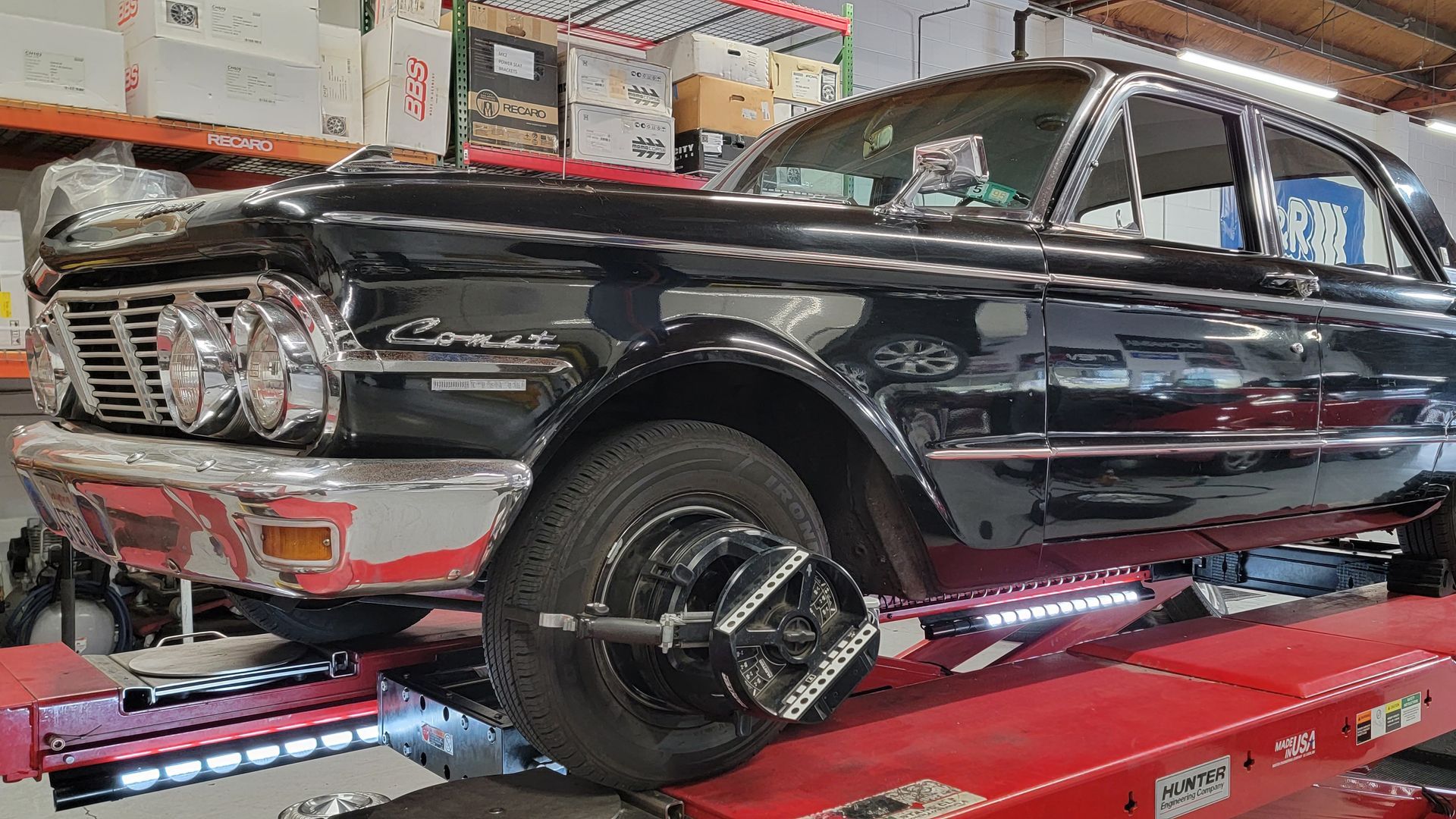 A black car is sitting on top of a red lift in a garage | Griffin Motorwerke