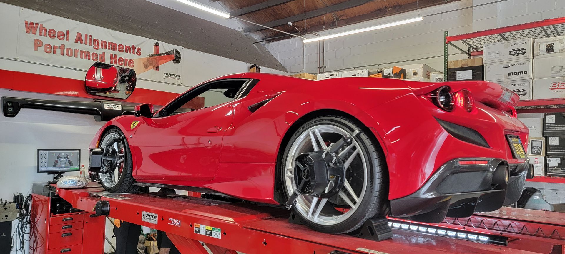 A red sports car is being adjusted in a garage | Griffin Motorwerke