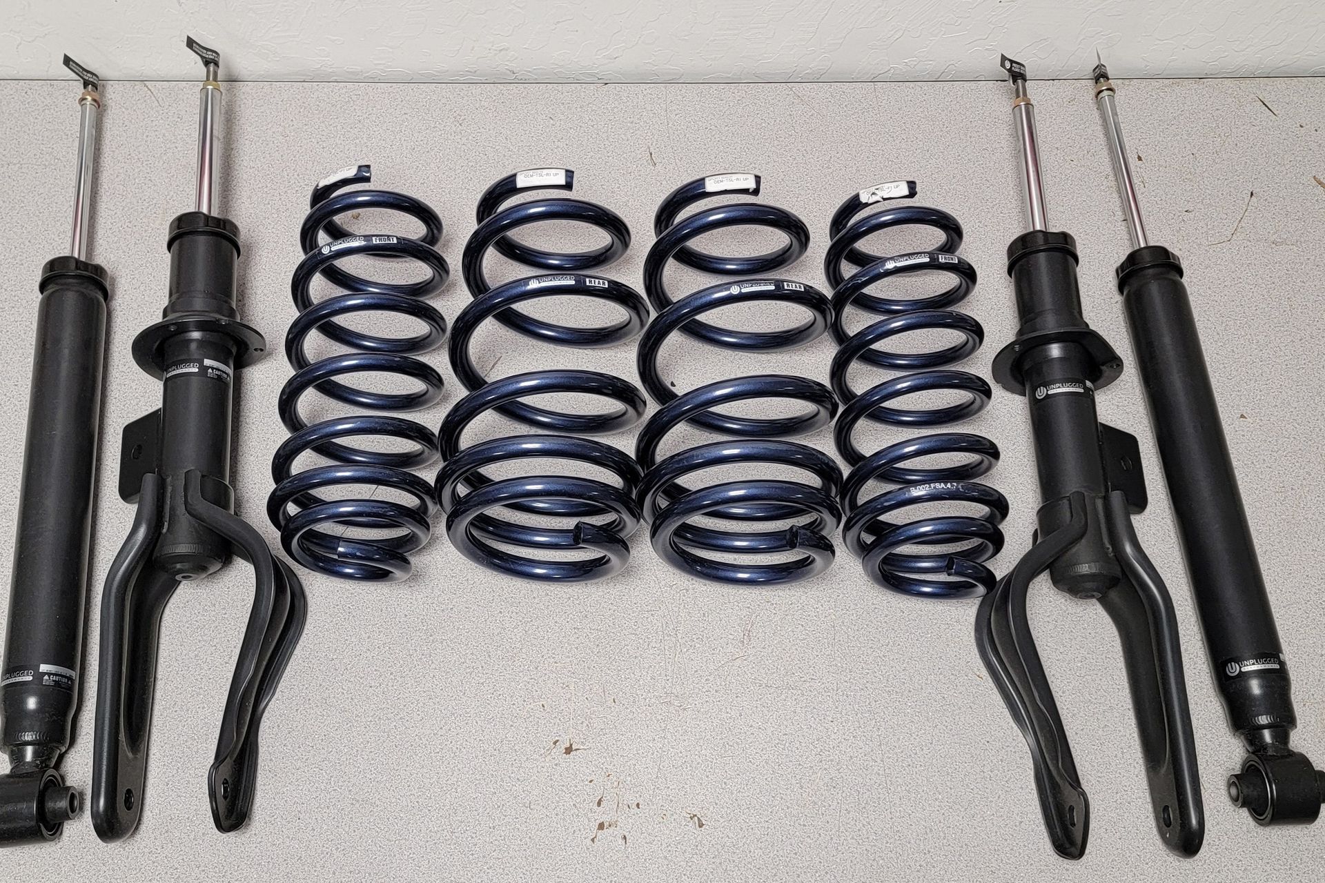 A bunch of shocks and springs are sitting on a table | Griffin Motorwerke
