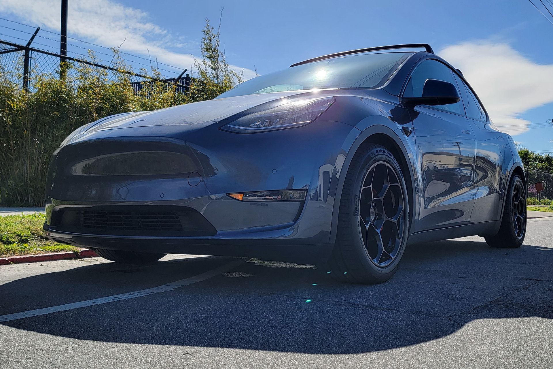 A tesla model y is parked in a parking lot on a sunny day | Griffin Motorwerke