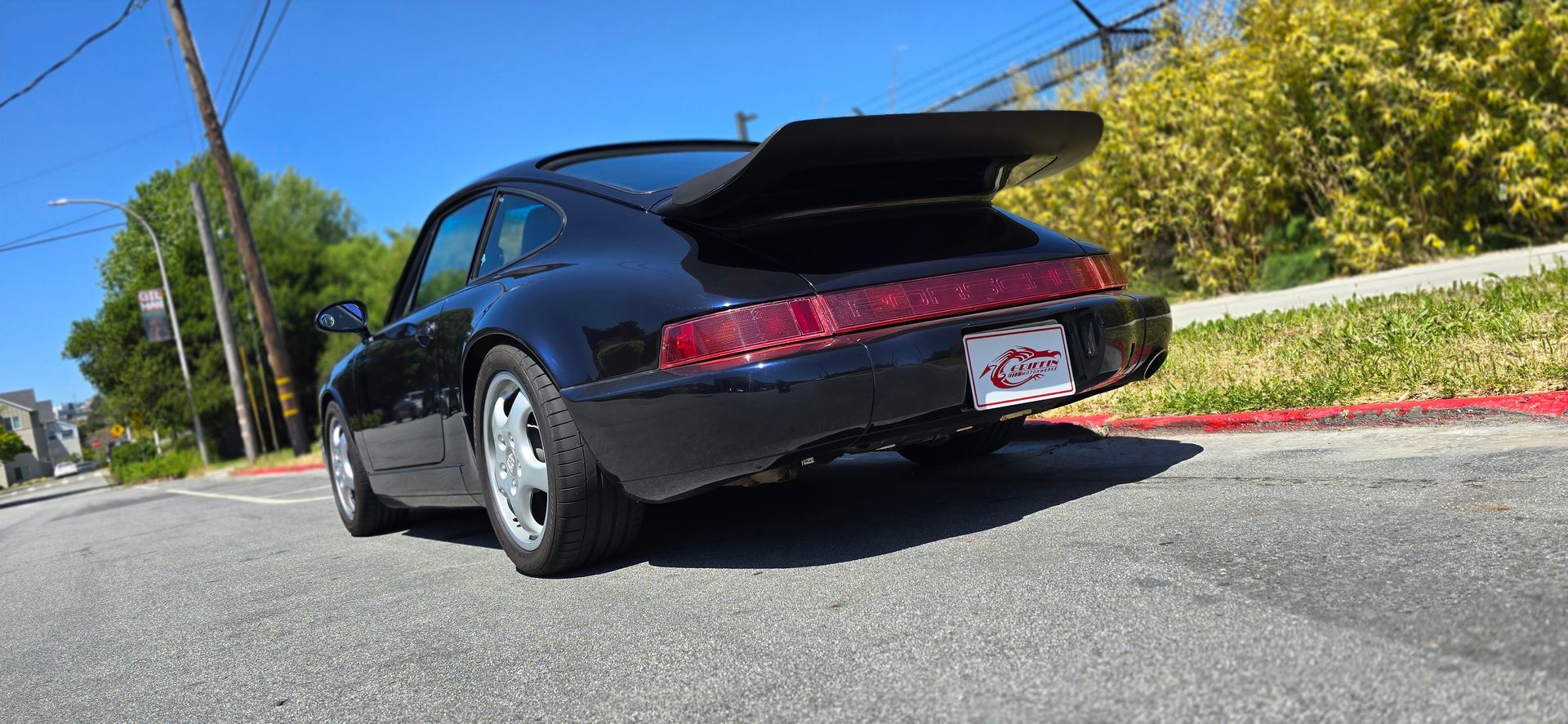 A black porsche 911 turbo is parked on the side of the road | Griffin Motorwerke
