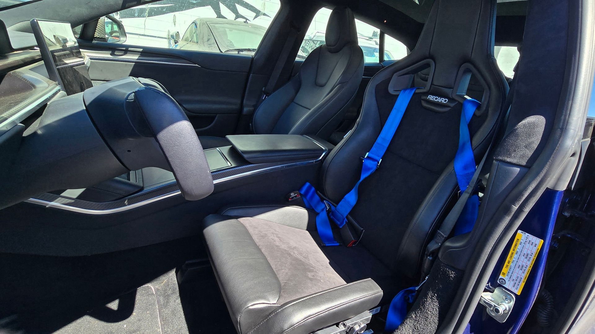 The front seat of a tesla model s with blue seat belts | Griffin Motorwerke