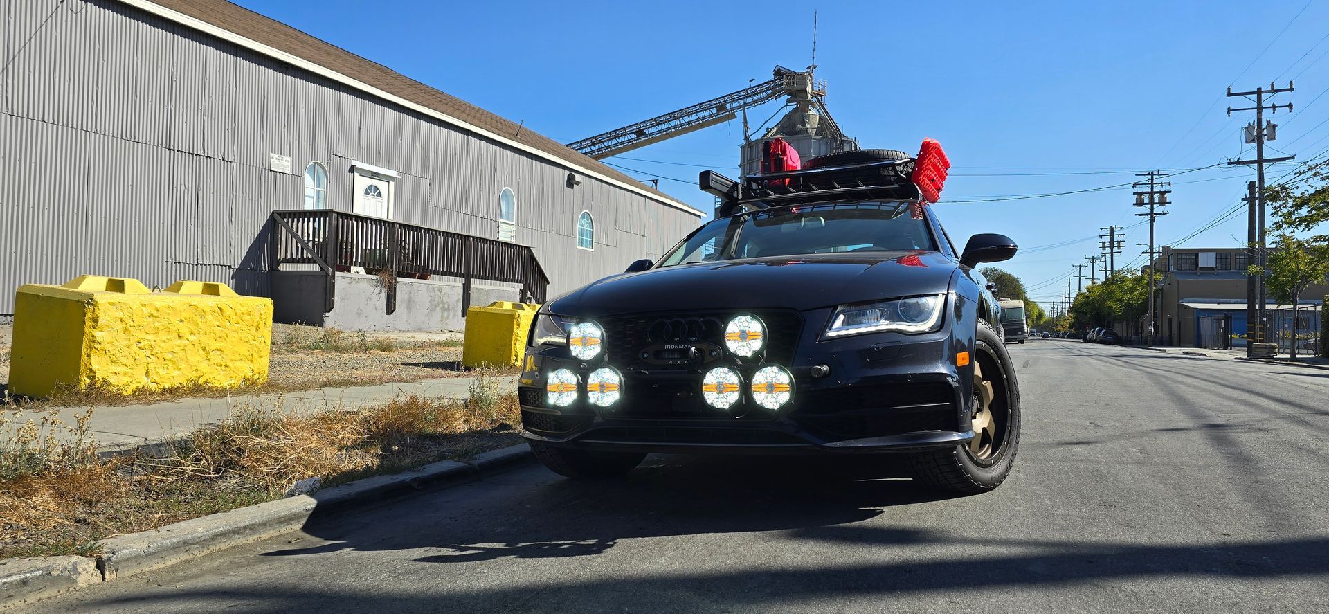 A black car with a crane on top of it is parked on the side of the road | Griffin Motorwerke