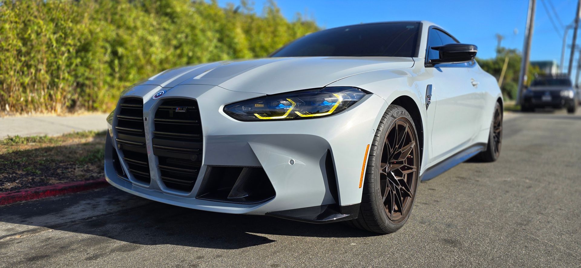 A white bmw m4 is parked on the side of the road | Griffin Motorwerke