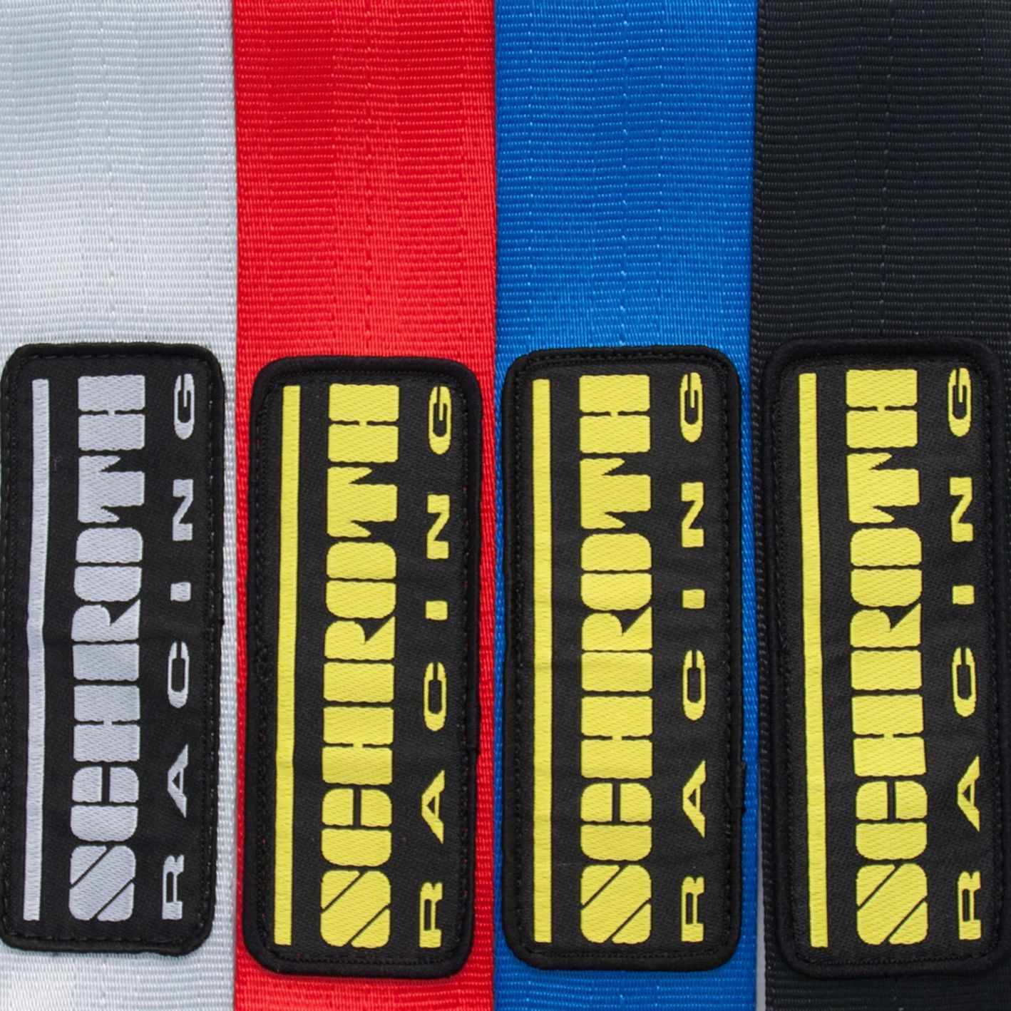 Four different colored schnroth racing belts are lined up in a row | Griffin Motorwerke