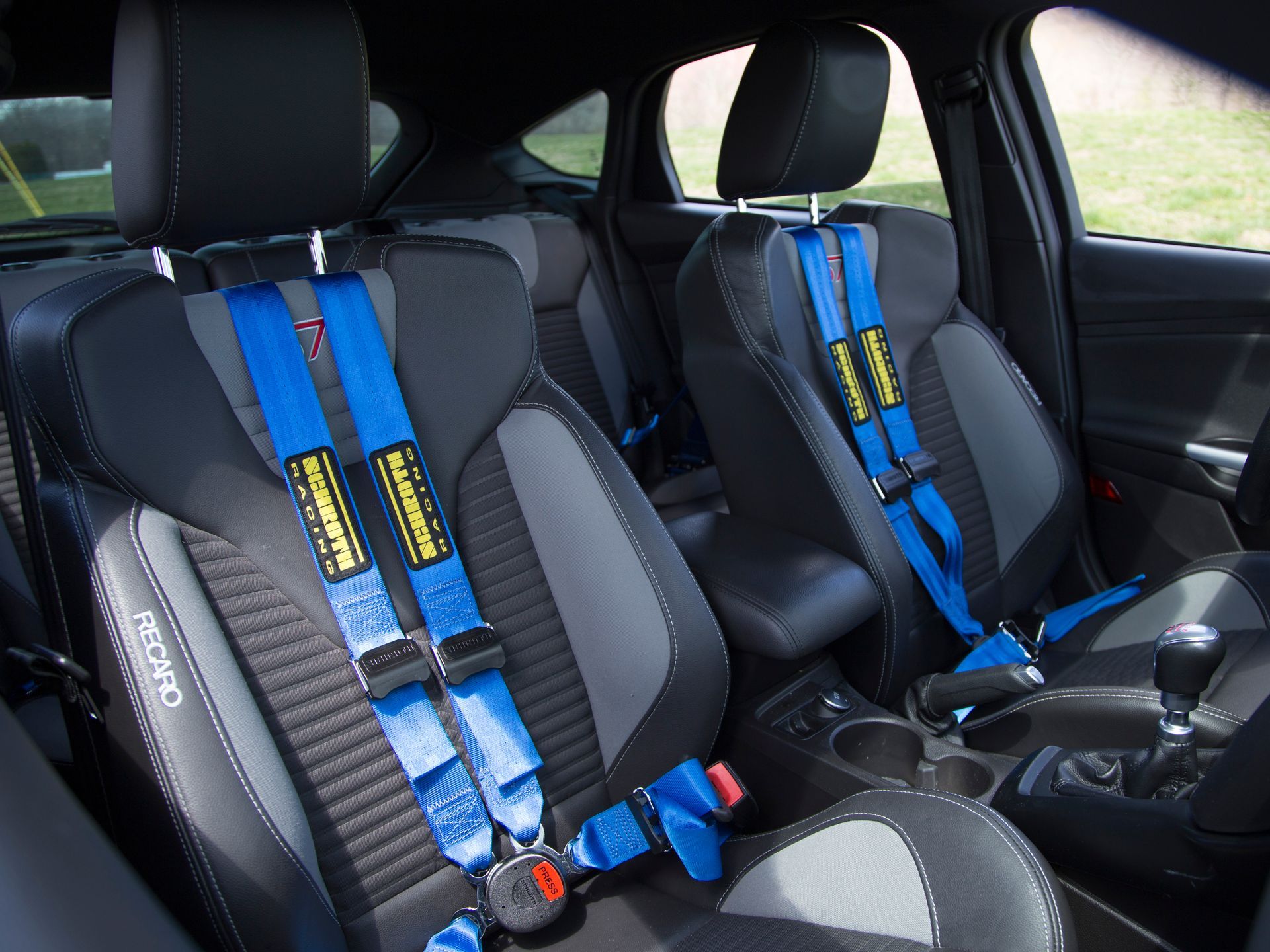 A black car with blue seat belts on the seats | Griffin Motorwerke