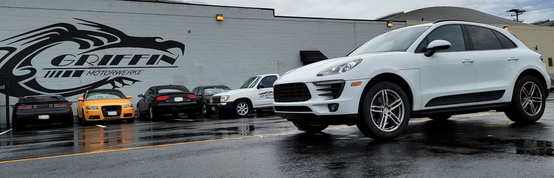 A white porsche macan is parked in front of a building | Griffin Motorwerke