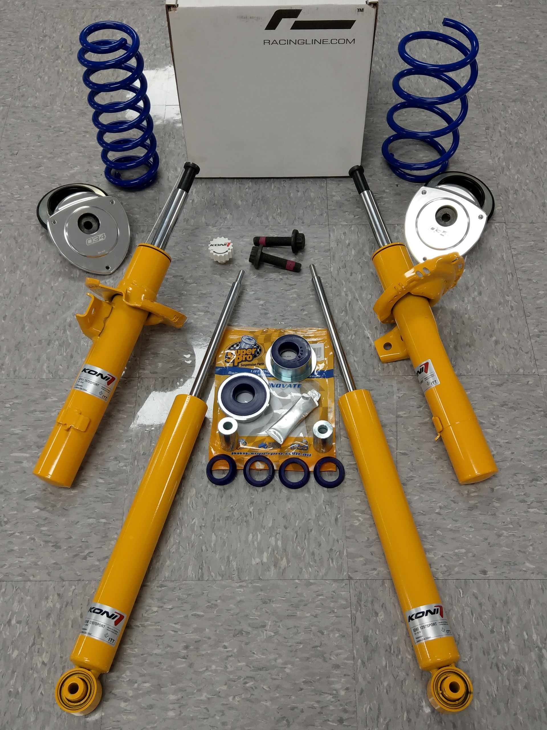 A pair of yellow shock absorbers are sitting next to a box of springs | Griffin Motorwerke