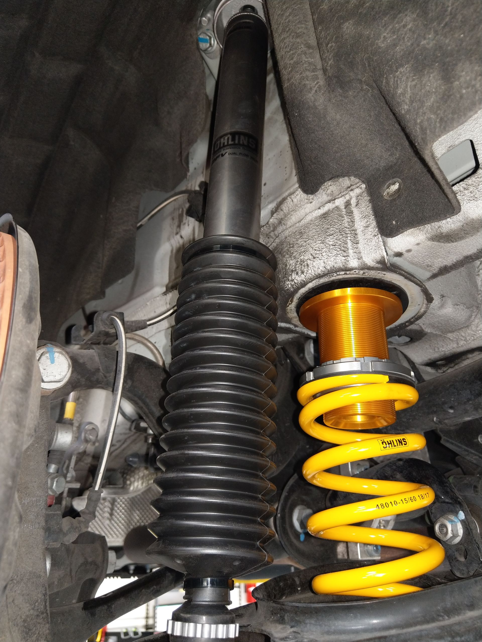 A close up of a car shock absorber with yellow springs | Griffin Motorwerke
