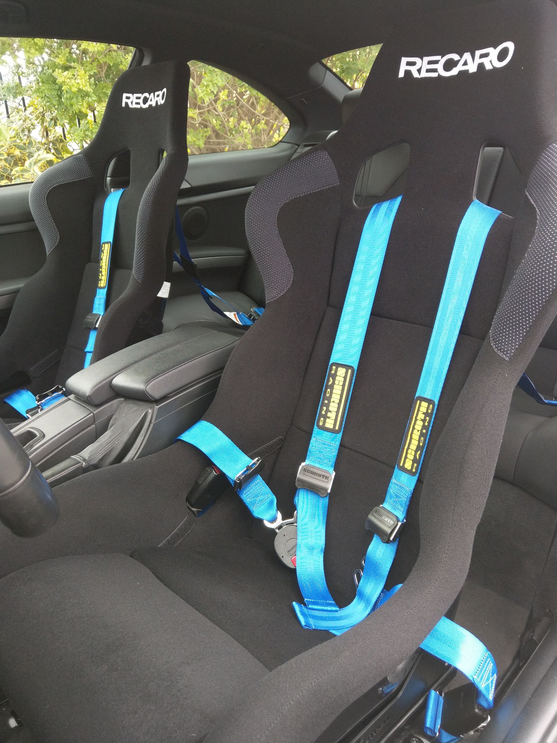 A black recaro seat with blue seat belts | Griffin Motorwerke