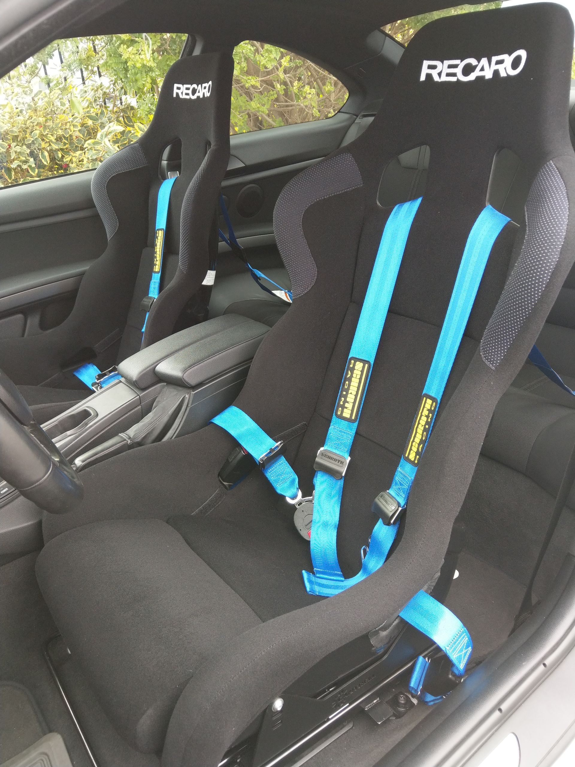 A black recaro seat with blue seat belts | Griffin Motorwerke