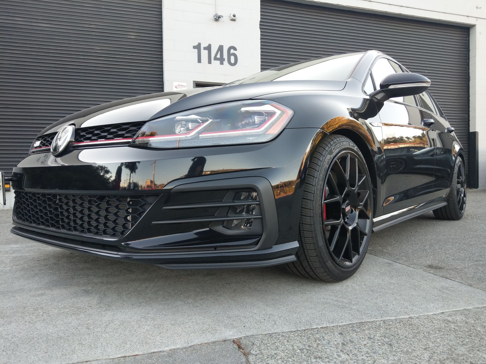 A black volkswagen golf gti is parked in front of a garage | Griffin Motorwerke