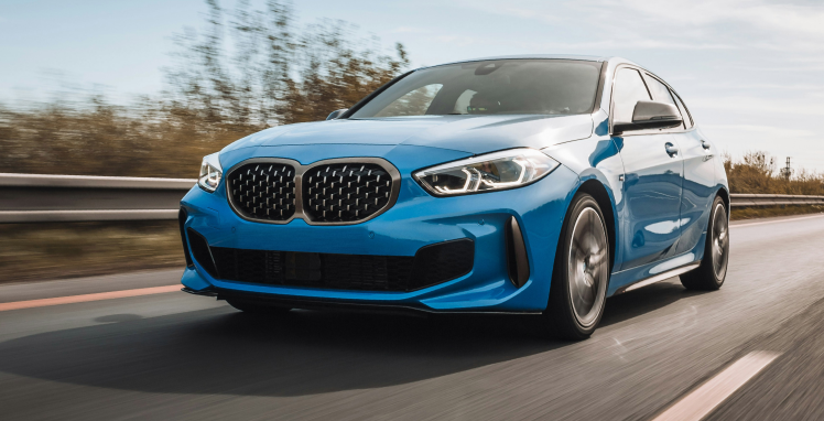 A blue bmw 1 series is driving down a highway | Griffin Motorwerke