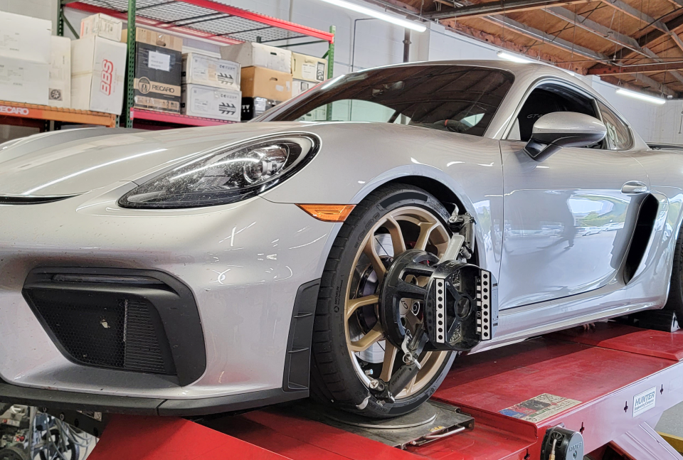 A silver sports car is sitting on top of a red lift in a garage | Griffin Motorwerke