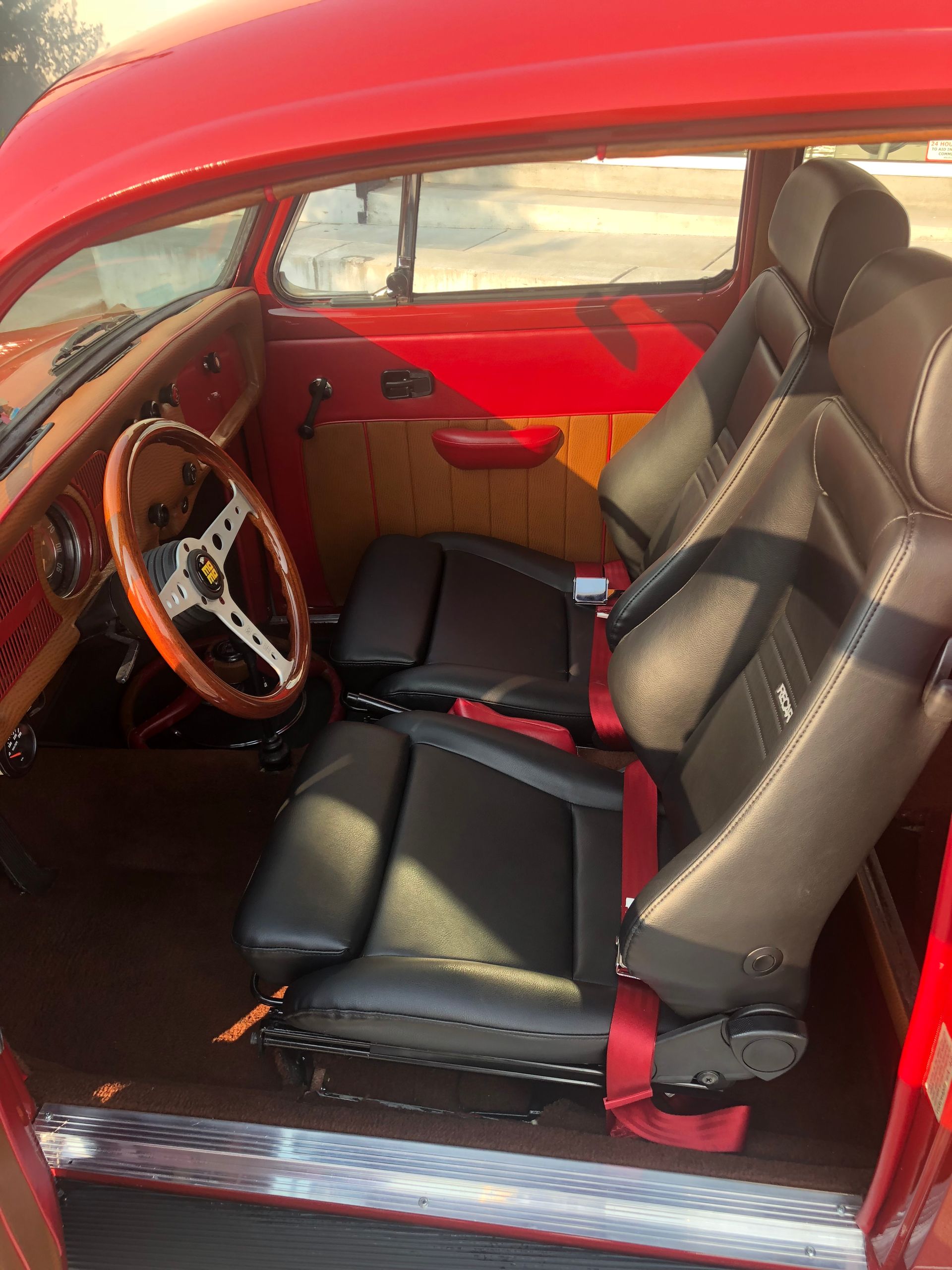 The interior of a red car with black seats and a steering wheel | Griffin Motorwerke