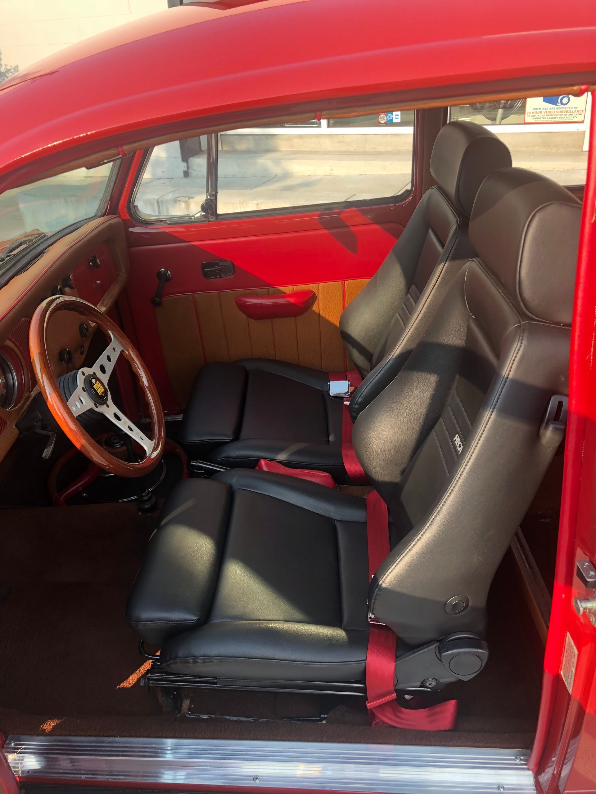 The inside of a red car with black seats and a steering wheel | Griffin Motorwerke