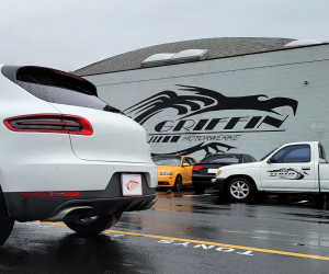 A white car is parked in front of a building that says griffin motorsports | Griffin Motorwerke