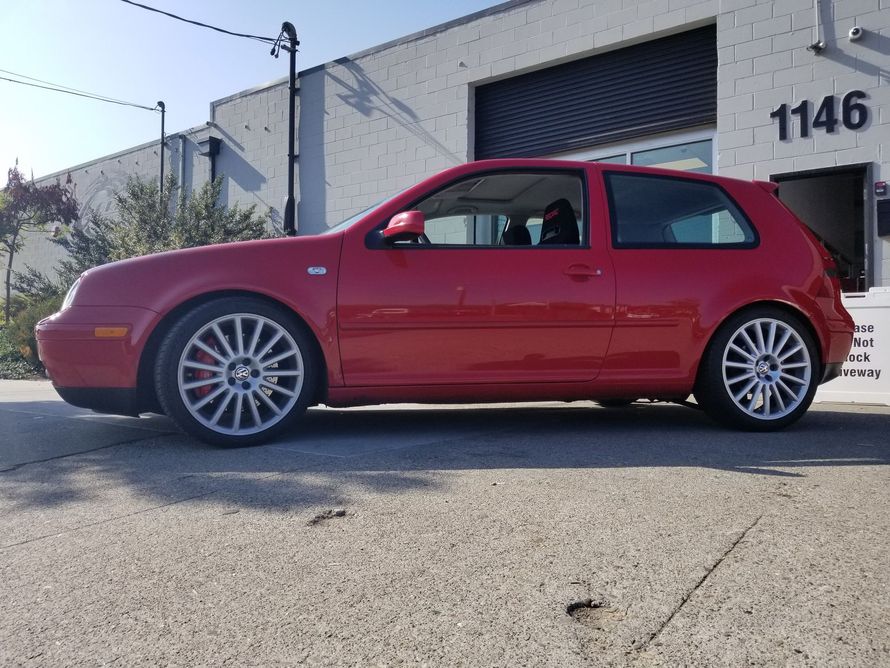 A red car is parked in front of a building with the number 1142 on it | Griffin Motorwerke