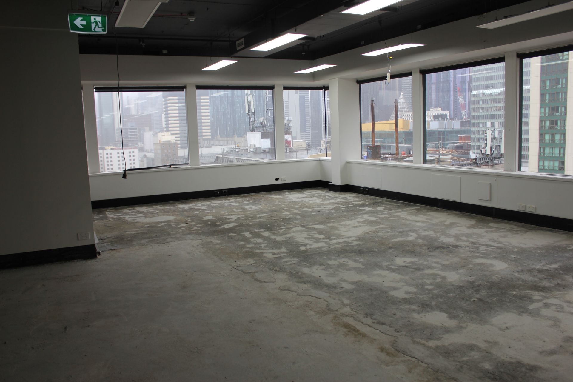 A man in a yellow vest is standing on a ladder