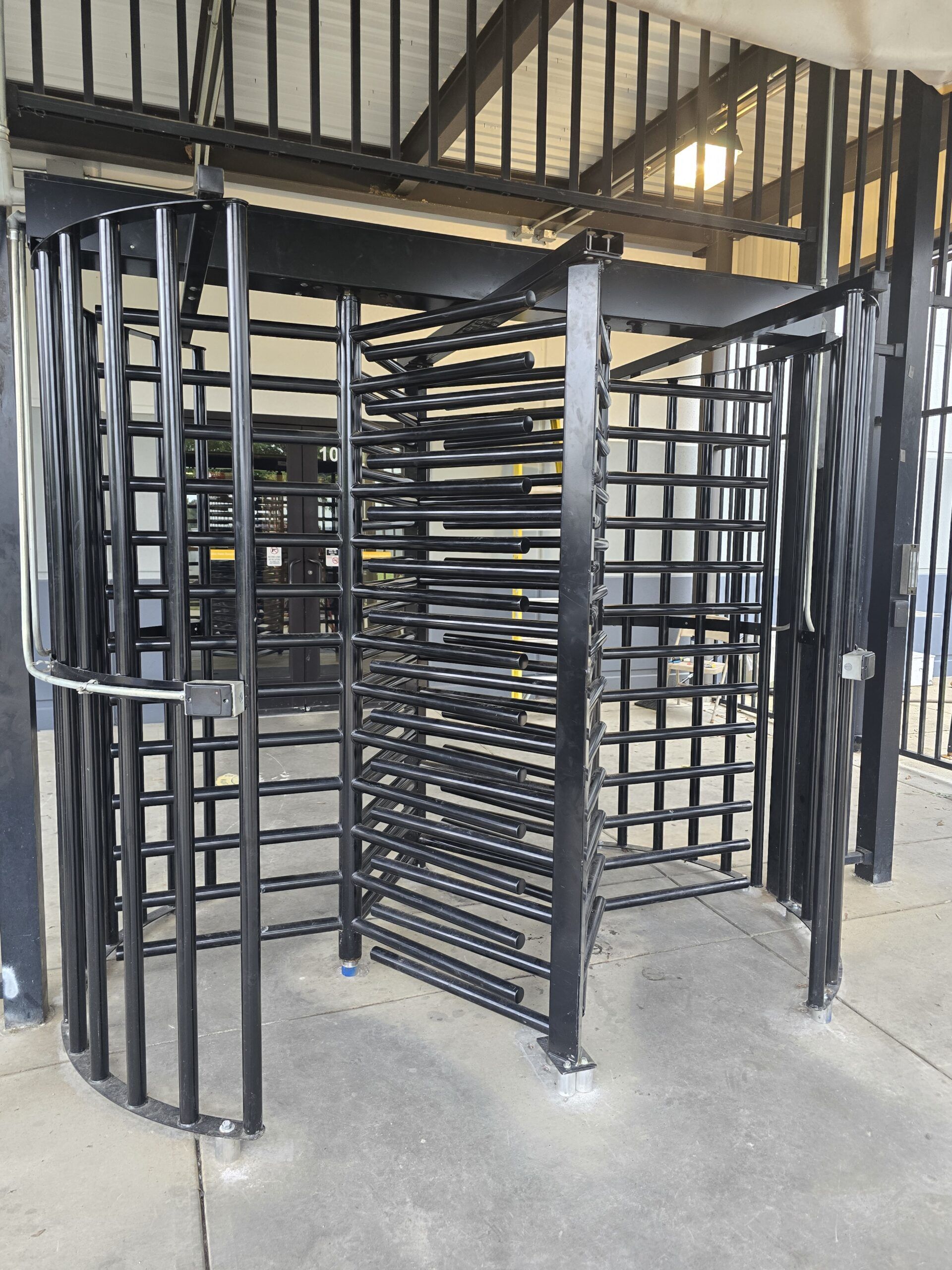 Black metal turnstile in an open entranceway.