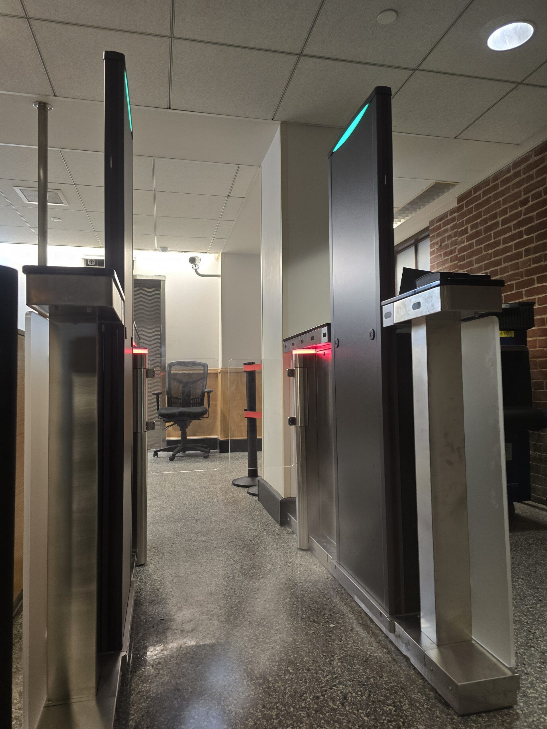 Security metal detectors with green and red lights, located indoors.