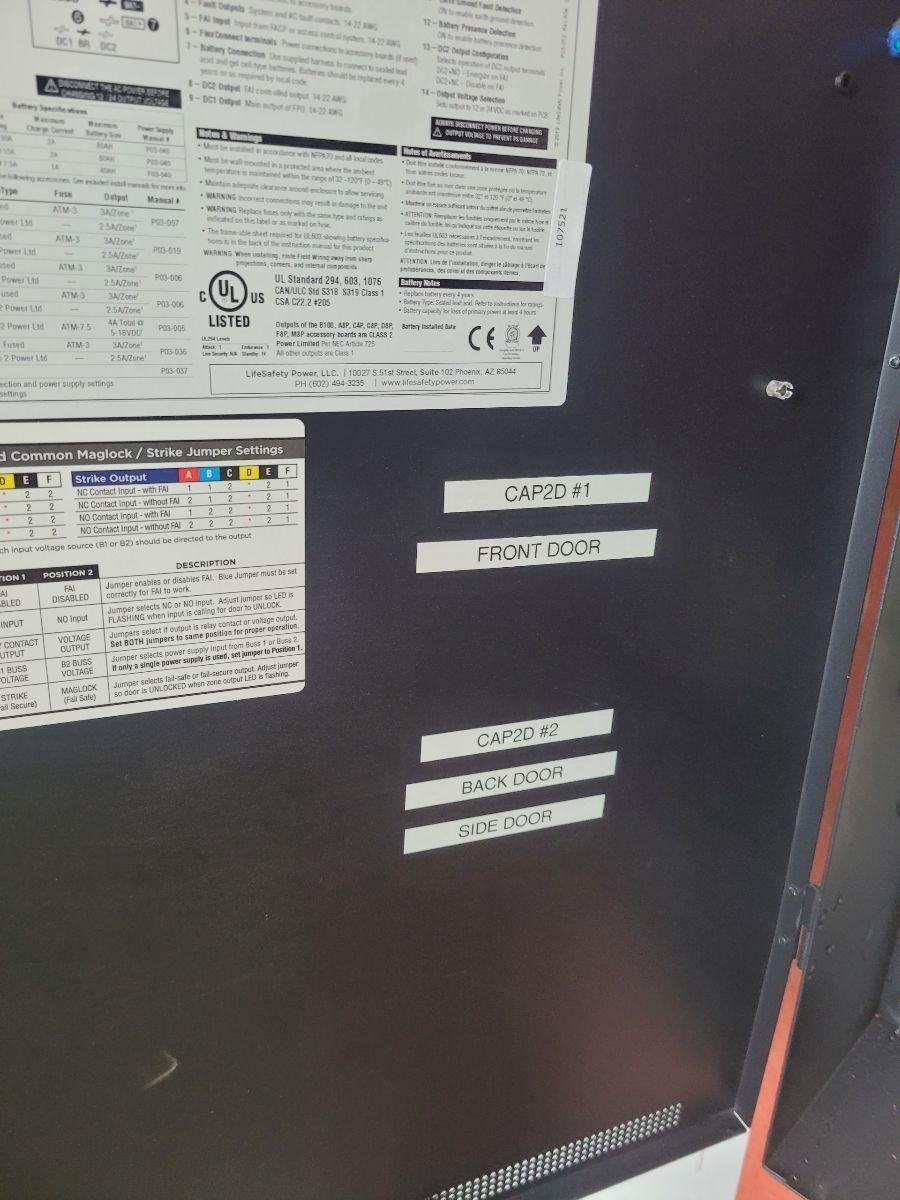 Black cabinet with paper labels, text including 