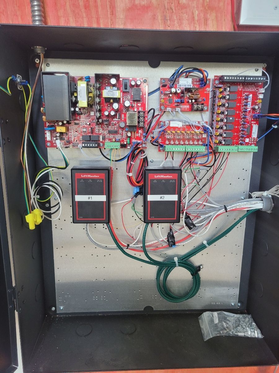 Electronic control panel with circuit boards, wiring, and access control readers.