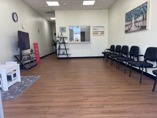 A waiting room with chairs and a tv on the wall