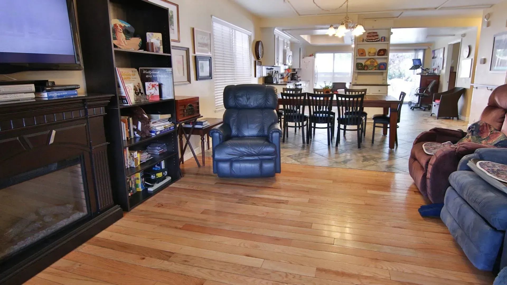 Living room with hardwood floors, a black recliner, and a dining table.