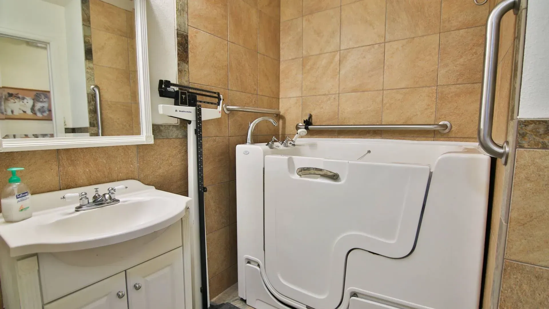 Bathroom with a walk-in bathtub, sink, and a grab bar. Beige tile walls.