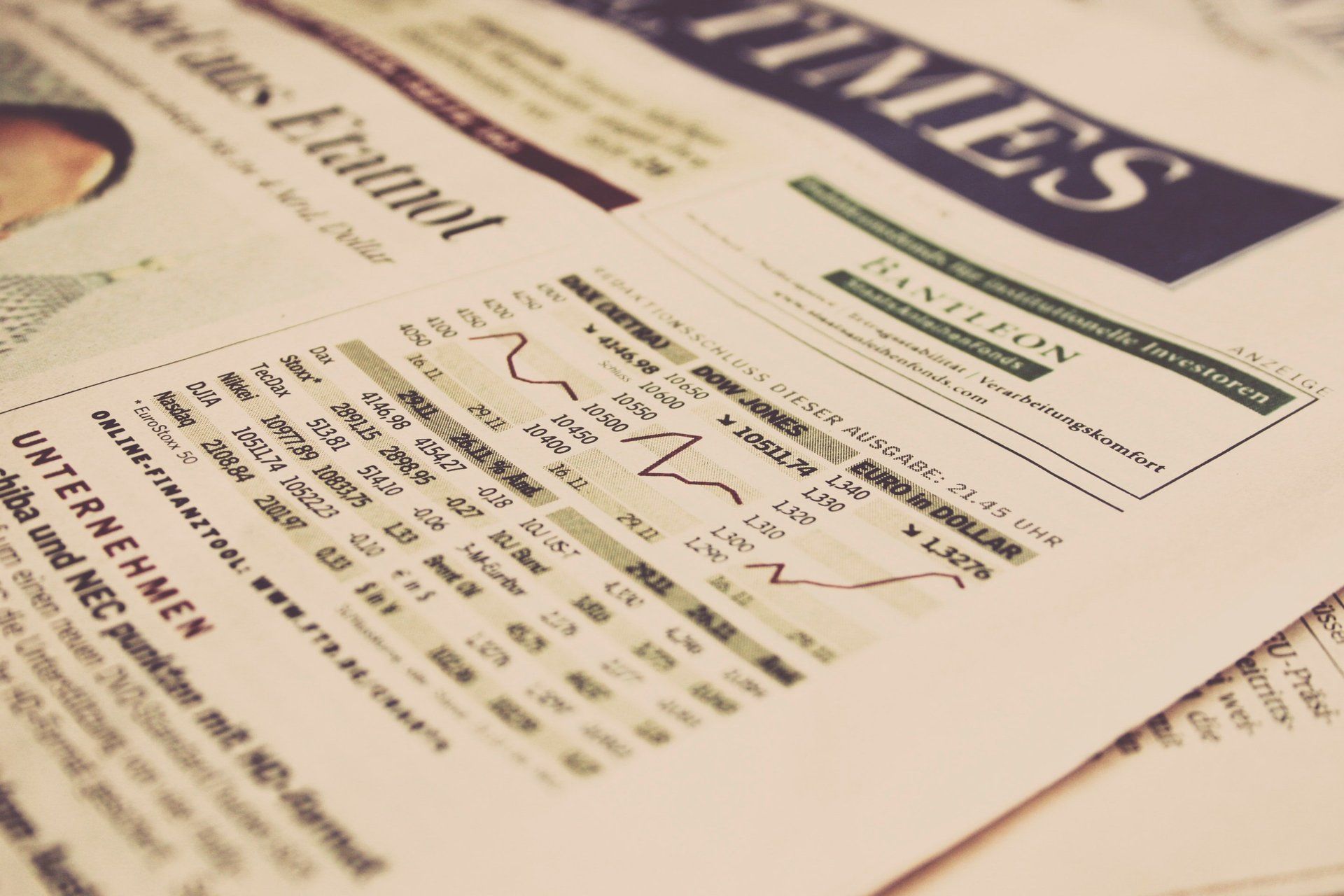 Newspaper with stock market data and a graph, vintage-toned, close-up.